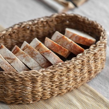 Hand woven basket rattan, bamboo, water hycinth, seagrass oval basket for holding bread and fruit, objects. Fashionable
